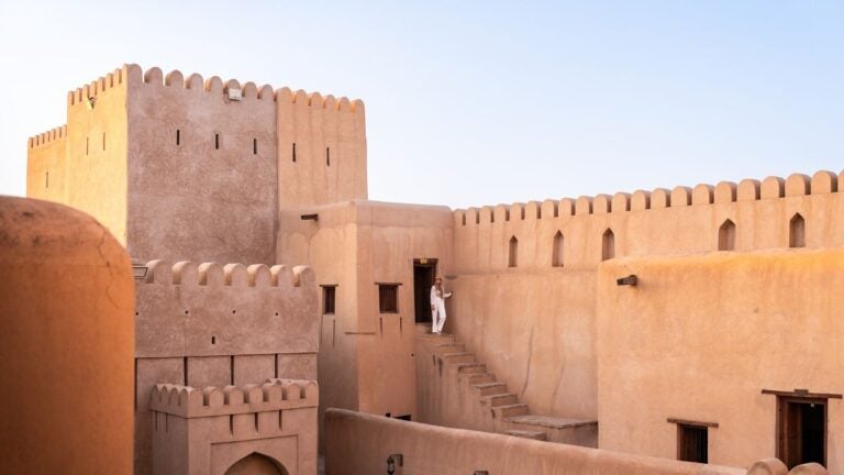 De zandkleurige muren en traditionele trappen van het historische Nizwa Fort in Oman.