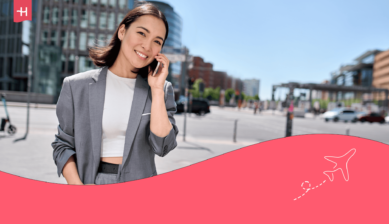 Een breed glimlachende vrouw die aan het bellen is als uitgelichte afbeelding van een artikel over Odido bellen naar het buitenland