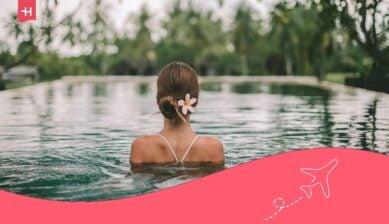 Een vrouw ontspant in een infinity pool omringd door tropische natuur op Bali