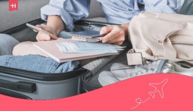 Reiziger pakt koffer in met telefoon en paspoort voor een paklijst voor Indonesië