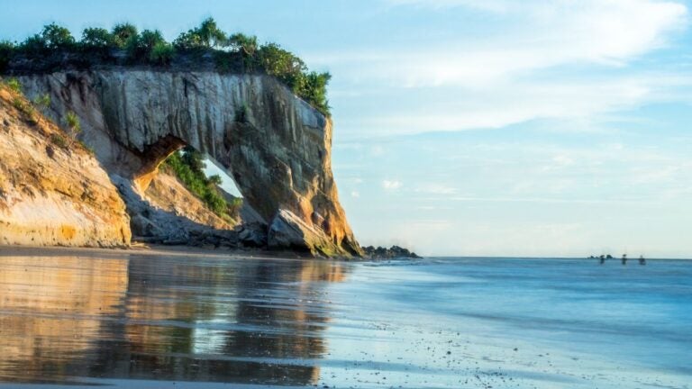 De indrukwekkende natuurlijke rotsboog van Tusan Beach in Maleisië tijdens het gouden uur – de beste reistijd voor Maleisië.