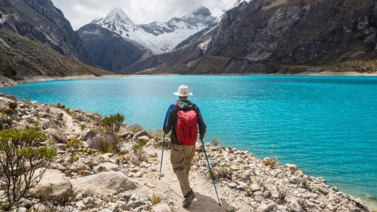 Wandelaar langs een bergmeer in Peru tijdens een trektocht