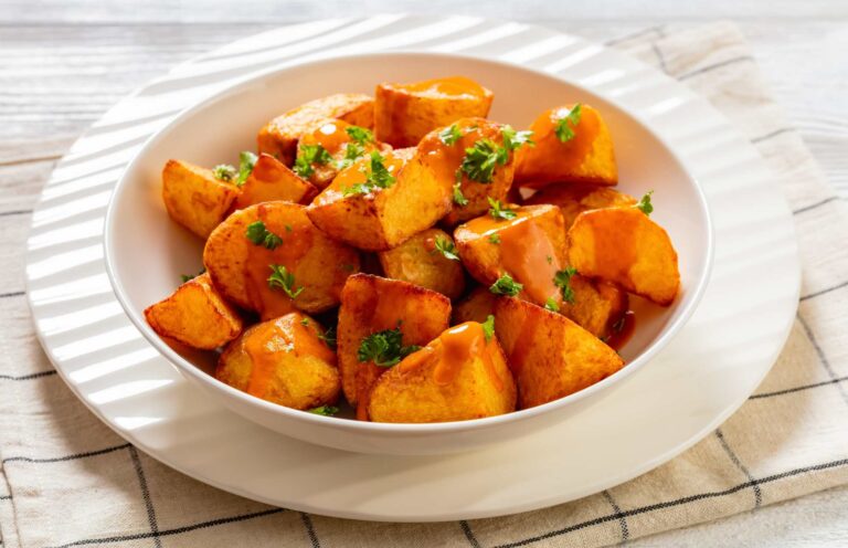 Patatas bravas met pittige saus en peterselie, een klassieke tapa uit de spanje eten cultuur