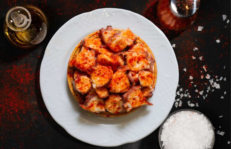Pulpo a la gallega met paprikapoeder en zeezout op een houten bord, een klassiek spanje eten gerecht
