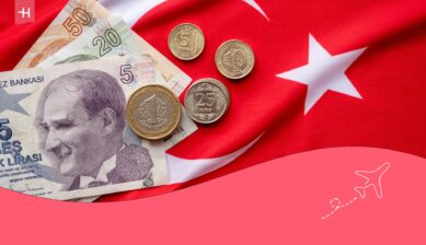 Turkse munten en briefjes met de Turkse vlag op de achtergrond als uitgelichte afbeelding voor een artikel over betalen in Turkije