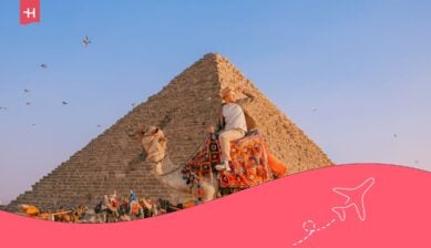 Toerist op een kameel voor de piramides van Giza, klaar om de Egypte eten cultuur en bezienswaardigheden te ontdekken