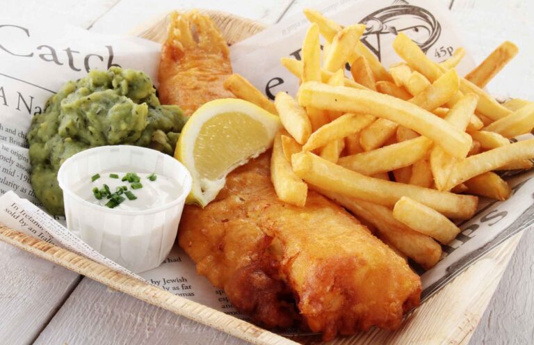 Klassieke Britse fish and chips geserveerd met friet, citroen en tartaarsaus