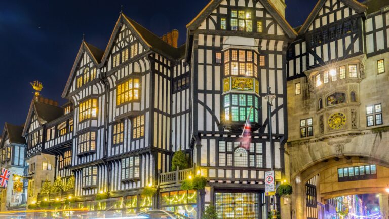 Historische gevel van Liberty London met vakwerkarchitectuur en avondverlichting.