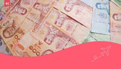 Een tafel vol briefjes Thaise Baht, als uitgelichte afbeelding voor een artikel over geld wisselen voor Thailand