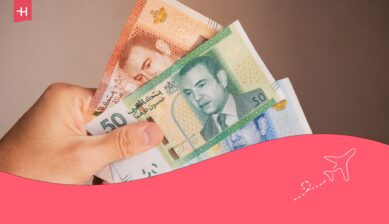 Een hand houdt drie briefjes Dirham vast, als uitgelichte afbeelding voor een artikel over in Marokko geld wisselen