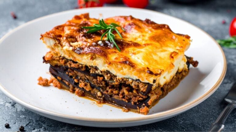 Moussaka met laagjes aubergine, gehakt en romige bechamelsaus op een bord.