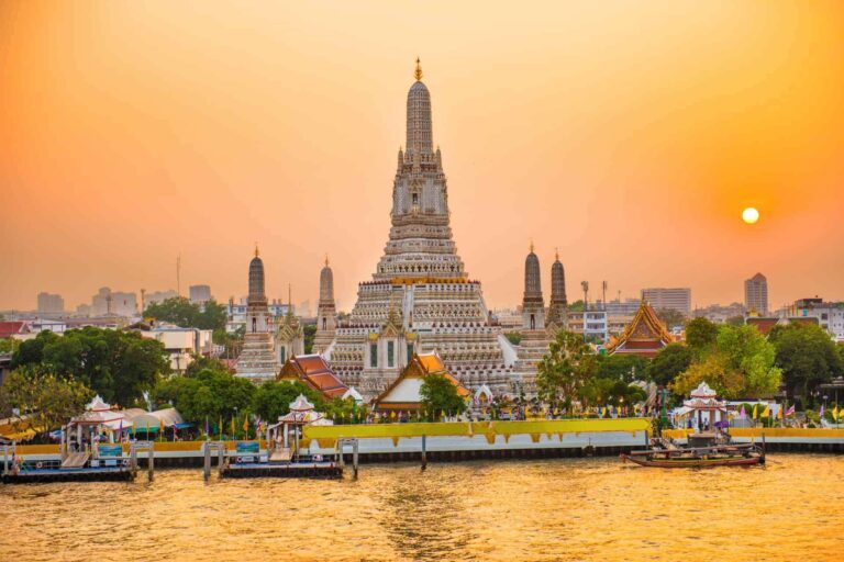Wat Arun in Bangkok aan de Chao Phraya-rivier bij zonsondergang.