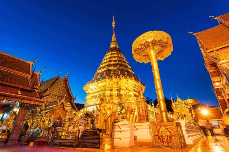De verlichte gouden stoepa van Wat Phra That Doi Suthep in Chiang Mai bij avond.