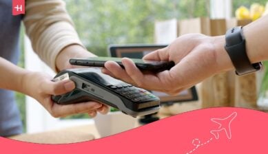 Persoon betaalt contactloos met een smartphone bij een betaalterminal.