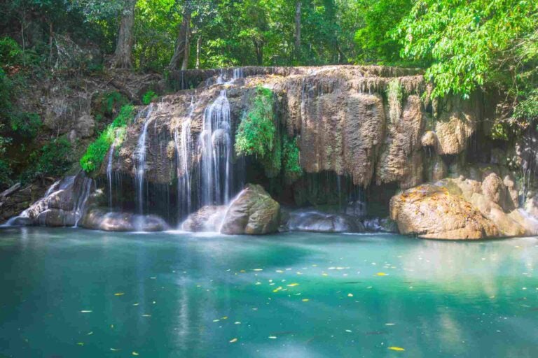 Erawan-waterval in Kanchanaburi met helder turquoise water en tropisch bos.