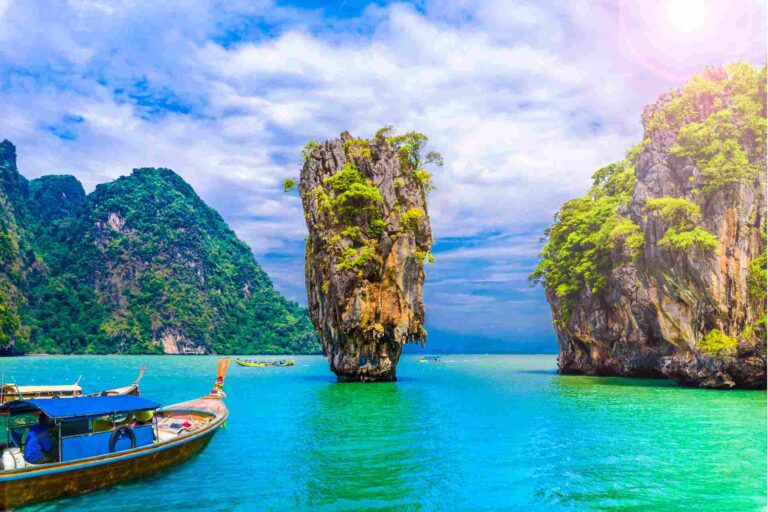 Longtailboot bij de kalkstenen rotsformaties van James Bond Island in de baai van Phang Nga, Thailand.