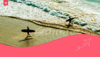 Twee surfers die uit het water komen als uitgelichte afbeelding voor een artikel over surfen in Frankrijk