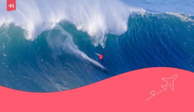 Surfer bedwingt een golf in Nazarè als uitgelichte afbeelding voor een artikel over surfen in Portugal
