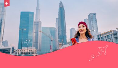 Vrouw met telefoon voor de Burj Khalifa als uitgelichte afbeelding voor een artikel over roaming in Dubai