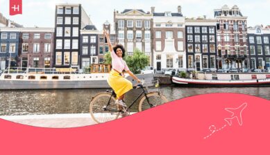 Vrouw op een fiets in Amsterdam als uitgelichte afbeelding voor een artikel over weetjes over Nederland