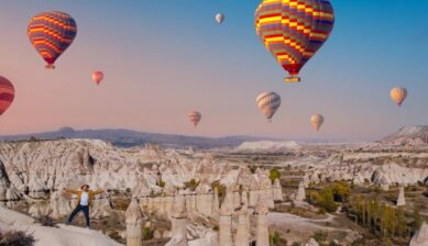 トルコ・カッパドキアの奇岩群（フェアリーチムニー）と、空に浮かぶ色とりどりの熱気球の風景