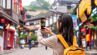 中国の古い街並みを散策しながら、eSIMを使ってスマートフォンで写真撮影している様子