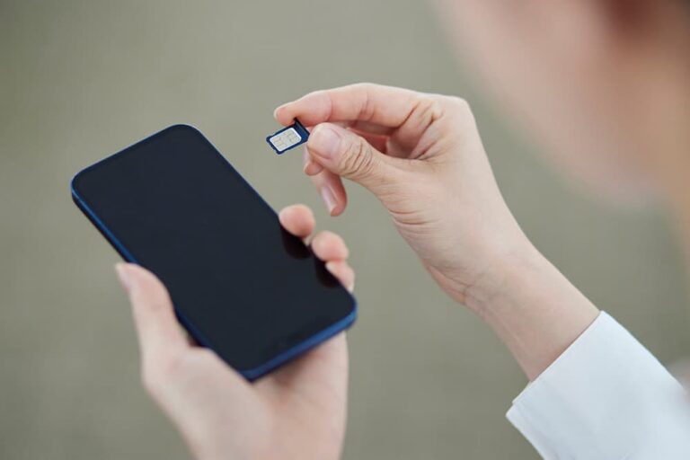 中国旅行の出発前や到着後の準備として、スマートフォンに物理SIMカードを挿入して通信設定を行っている手元の様子