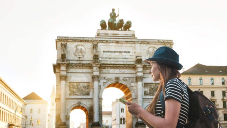ドイツ・ミュンヘンのジークトーア（勝利の門）の前で、地図アプリを見ながら観光する女性