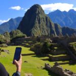 ALT
ペルー・マチュピチュ遺跡を背景に、スマートフォンを手に風景を眺める女性