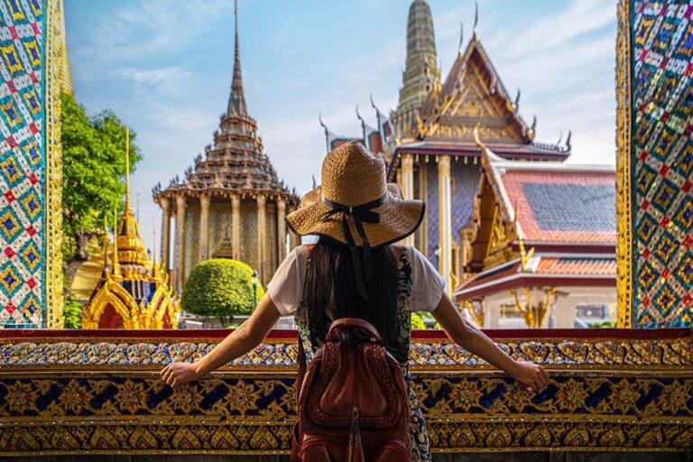 タイ・バンコクの王宮で金色の寺院を眺める後ろ姿の女性旅行者