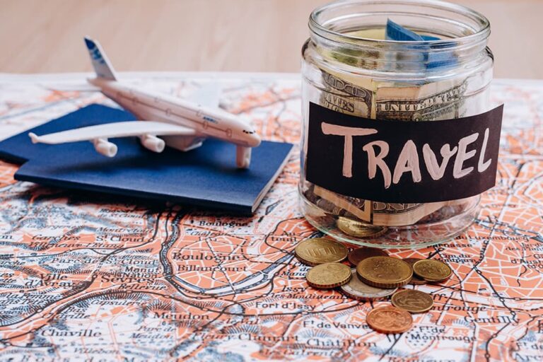 旅行費用をイメージした、お金の入った瓶と飛行機・地図