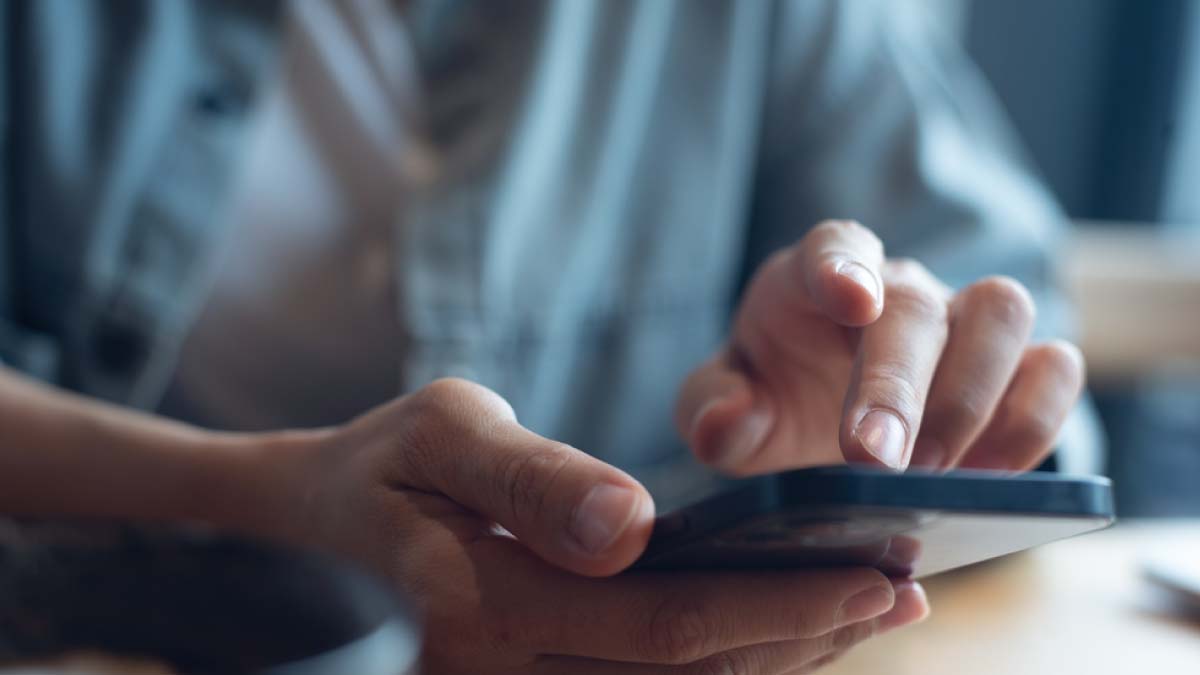 スマートフォンで連絡先を確認・入力する手元のクローズアップ。