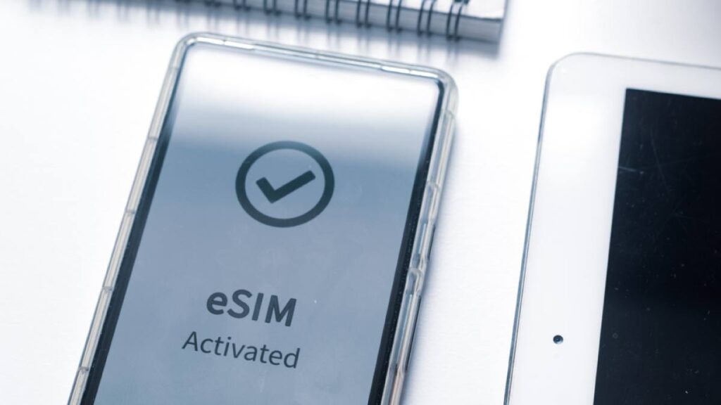 「eSIM Activated」と表示されたスマートフォンの画面とタブレット