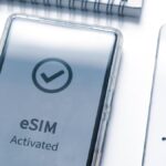 「eSIM Activated」と表示されたスマートフォンの画面とタブレット