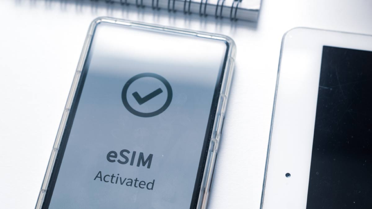 「eSIM Activated」と表示されたスマートフォンの画面とタブレット
