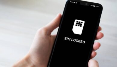 「SIM LOCKED」と表示されたスマートフォン画面を手に持ち、SIMロック状態を示している様子