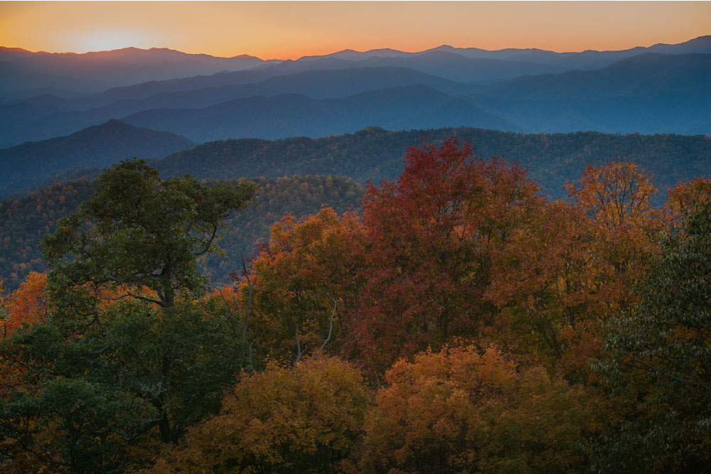 グレート・スモーキー山脈国立公園での秋の夕景。山並みが重なり、紅葉した木々が鮮やかに彩りを添えている。