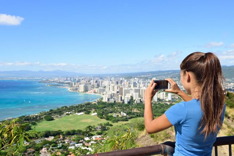 Tシャツの夏服でワイキキの街並みを眺める女性。ハワイ旅行の服装の一例