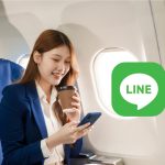 飛行機の客席に座りながらスマートフォンを操作している女性。画像には「LINE」のロゴも重ねられている。