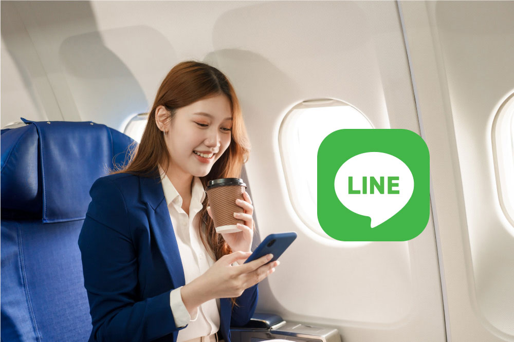 飛行機の客席に座りながらスマートフォンを操作している女性。画像には「LINE」のロゴも重ねられている。