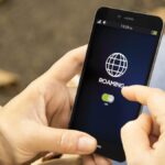 スマートフォンの画面に表示されたローミング設定をオンにする様子