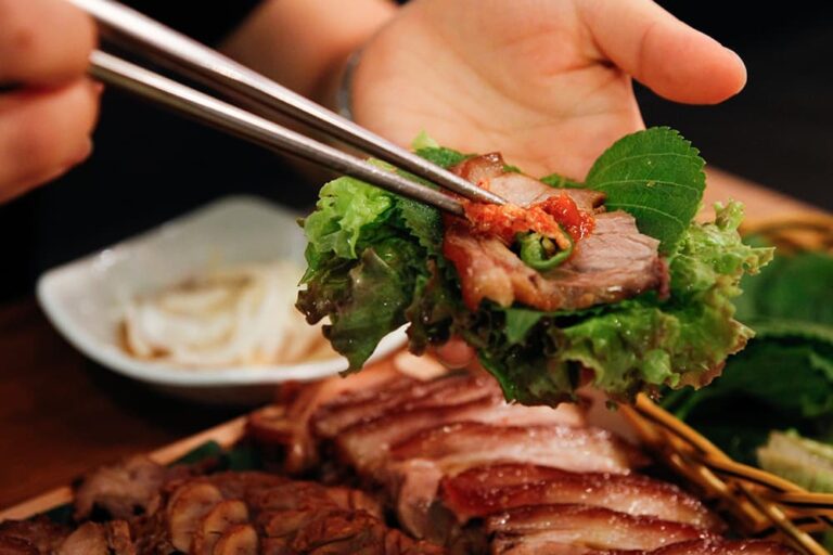 韓国旅行の食費をイメージした、サンチュでお肉と薬味を包んで食べる本格的な韓国焼肉の様子
