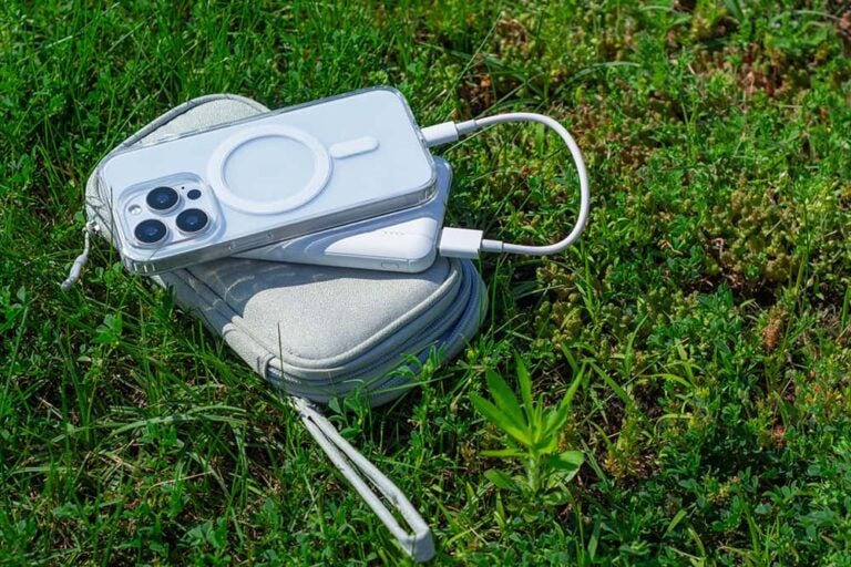 韓国旅行の外出先でスマートフォンの充電切れを防ぐ、芝生の上で充電中の白いモバイルバッテリー