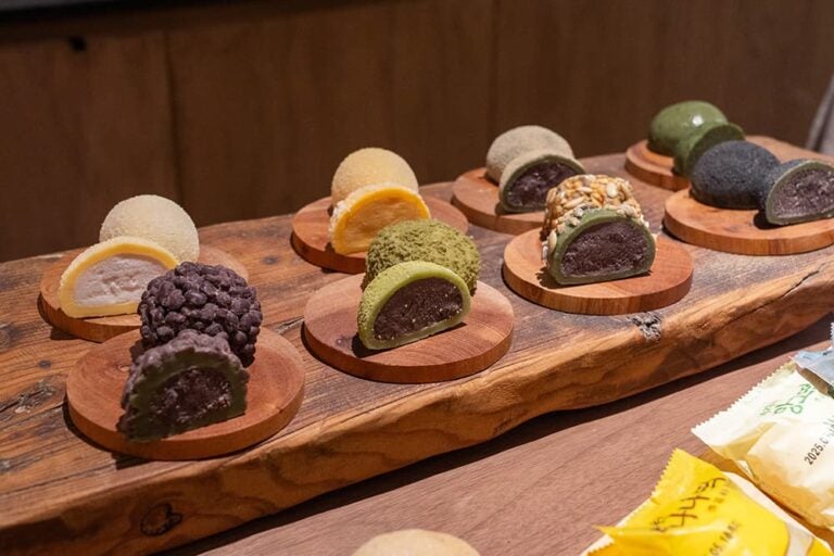 韓国旅行での買い物やお土産代をイメージした、さまざまな餡が詰まった色鮮やかな韓国伝統菓子(お餅)のディスプレイ