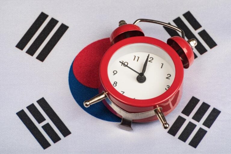 韓国の国旗の上に置かれた赤い目覚まし時計。