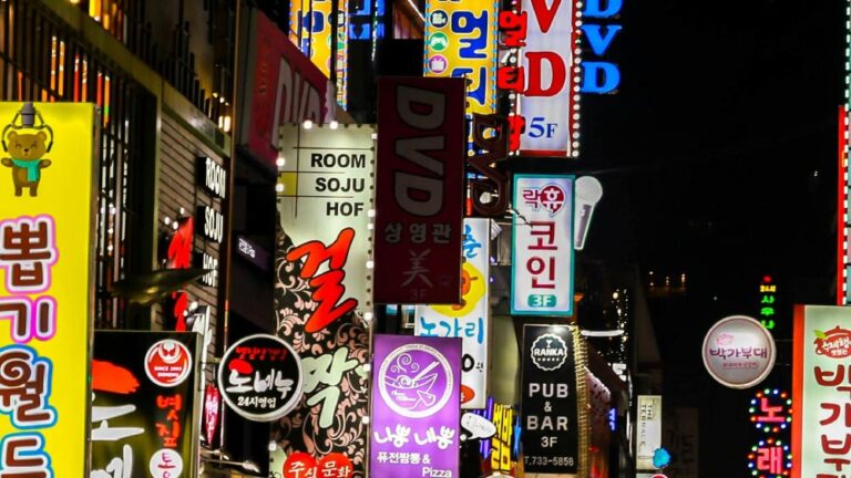 ソウルの夜の繁華街の様子。多数の韓国語のネオンサインや看板が立ち並び、飲食店や娯楽施設が賑わっている。