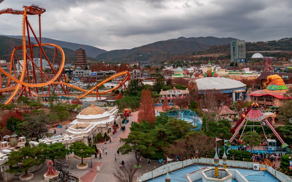 韓国・大邱にあるEワールド遊園地の風景。巨大なジェットコースターや観覧車などのアトラクションが並び、華やかな雰囲気が広がる。