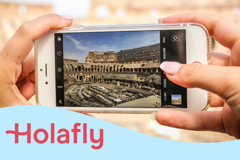 コロッセオをスマホで撮影する手元の写真。eSIMストアのHolalfyの文字。