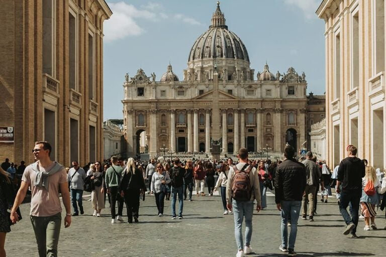 イタリアのサンピエトロ寺院へ向かう長袖長ズボンを着た人々の写真