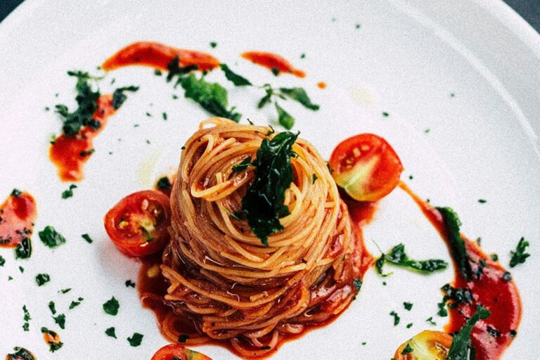 イタリア料理レストランで出てきた白い器の上に盛られたトマトパスタの写真